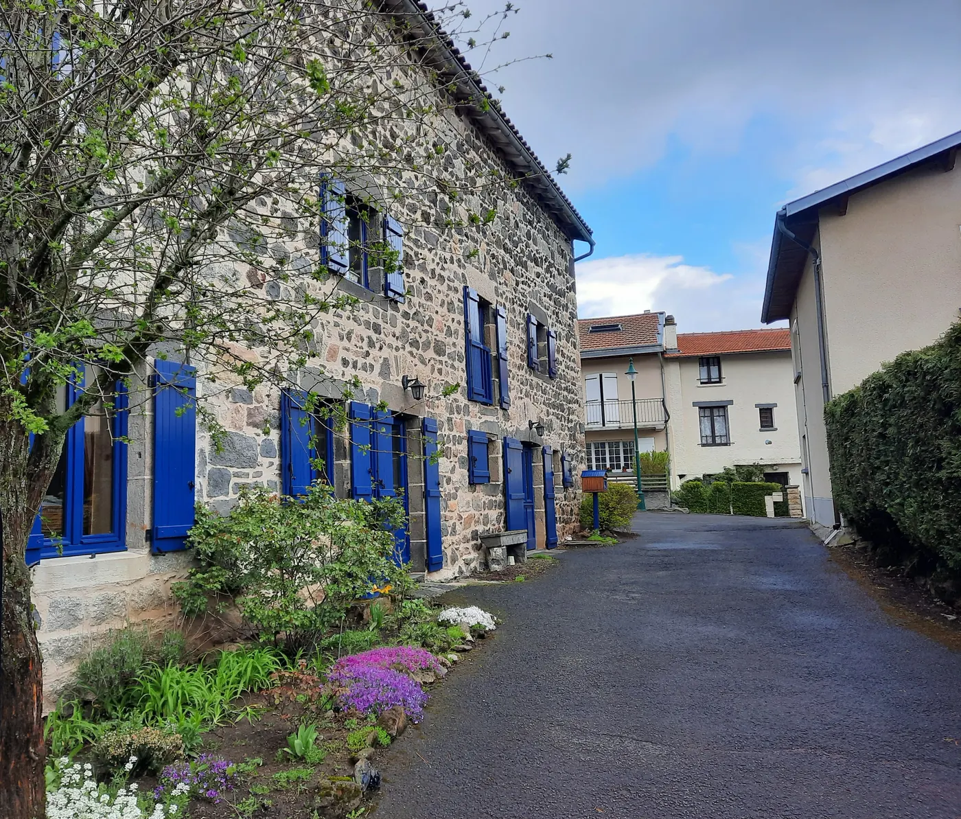 Maison en pierre aux volets bleus repeints